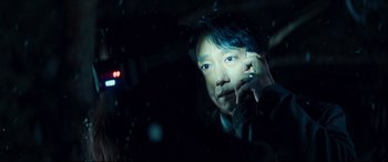Movie still from “Decision to Leave” (2022), directed by Park Chan-wook – A man sitting in the back seat of a car at night; Close Up shot, Over the shoulder angle
