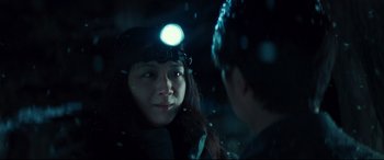 Movie still from “Decision to Leave” (2022), directed by Park Chan-wook – A woman with a headlamp on talking to a man in the dark; Close Up shot, Over the shoulder angle
