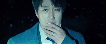 Movie still from “Decision to Leave” (2022), directed by Park Chan-wook – A person wearing a suit and tie; Close Up shot, Over the shoulder angle