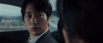 Movie still from “Decision to Leave” (2022), directed by Park Chan-wook – A person wearing a suit and tie; Close Up shot, Over the shoulder angle