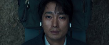 Movie still from “Decision to Leave” (2022), directed by Park Chan-wook – A person wearing ear buds; Close Up shot, Overhead angle