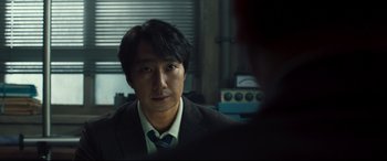 Movie still from “Decision to Leave” (2022), directed by Park Chan-wook – A man wearing a suit and tie in front of a mirror; Close Up shot, Over the shoulder angle