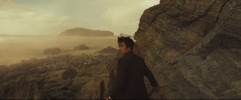 Movie still from “Decision to Leave” (2022), directed by Park Chan-wook – A man standing on top of a rock cliff; Wide shot, Low angle