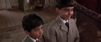 Movie still from “Gandhi” (1982), directed by Richard Attenborough – Two young boys in suits and ties looking at the camera; Close Up shot, Over the shoulder angle