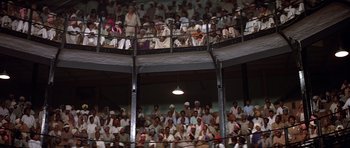 Movie still from “Gandhi” (1982), directed by Richard Attenborough – A group of people sitting on top of a stage; Extreme Wide shot, High angle
