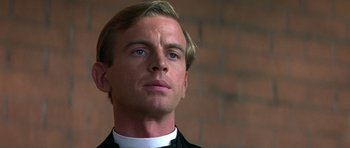 Movie still from “Gandhi” (1982), directed by Richard Attenborough – A man in a clerical collar looking to his left; Close Up shot, Low angle