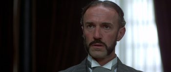 Movie still from “Gandhi” (1982), directed by Richard Attenborough – A person wearing a suit and tie; Close Up shot, Low angle