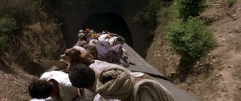 Movie still from “Gandhi” (1982), directed by Richard Attenborough – A group of people sitting on top of a train track; Wide shot, High angle