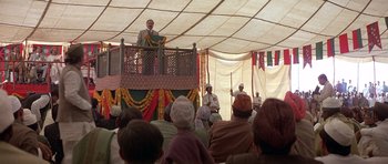 Movie still from “Gandhi” (1982), directed by Richard Attenborough – A man is speaking to a group of people; Wide shot, Low angle