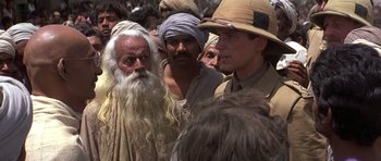 Movie still from “Gandhi” (1982), directed by Richard Attenborough – A group of men standing next to each other in a crowd; Close Up shot, Over the shoulder angle