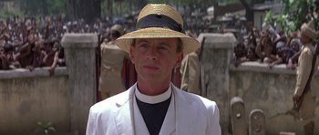 Movie still from “Gandhi” (1982), directed by Richard Attenborough – A man wearing a straw hat and a white jacket; Close Up shot, Over the shoulder angle