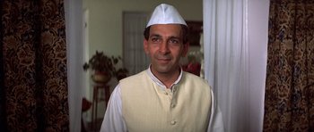 Movie still from “Gandhi” (1982), directed by Richard Attenborough – A man wearing a white hat is smiling for the camera; Close Up shot, Low angle
