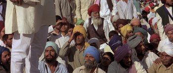 Movie still from “Gandhi” (1982), directed by Richard Attenborough – A group of men wearing turbans and sitting in a crowd; Medium shot, High angle