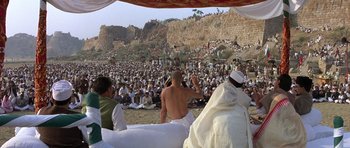 Movie still from “Gandhi” (1982), directed by Richard Attenborough – A crowd of people sitting and standing in front of an audience; Extreme Wide shot, High angle