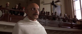 Movie still from “Gandhi” (1982), directed by Richard Attenborough – A man with a beard and mustache wearing a white robe; Close Up shot, Low angle
