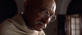 Movie still from “Gandhi” (1982), directed by Richard Attenborough – An old man with glasses and a mustache; Close Up shot, Low angle