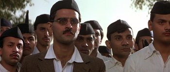 Movie still from “Gandhi” (1982), directed by Richard Attenborough – A group of men wearing hats and glasses; Close Up shot, Low angle
