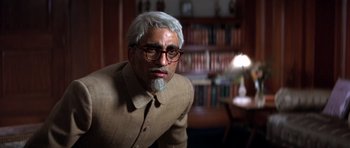 Movie still from “Gandhi” (1982), directed by Richard Attenborough – An older man wearing glasses and a tan jacket; Medium shot, Low angle