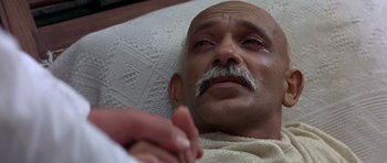 Movie still from “Gandhi” (1982), directed by Richard Attenborough – An old man with a mustache is laying in a bed; Close Up shot, High angle
