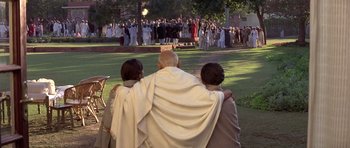 Movie still from “Gandhi” (1982), directed by Richard Attenborough – A group of people standing in the grass; Wide shot, High angle