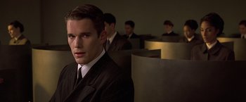 Movie still from “Gattaca” (1997), directed by Andrew Niccol – A man wearing a suit and tie in a room; Close Up shot, Over the shoulder angle