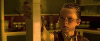 Movie still from “Gattaca” (1997), directed by Andrew Niccol – A young man wearing glasses in a kitchen; Close Up shot, Over the shoulder angle