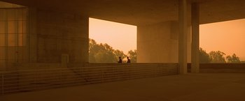 Movie still from “Gattaca” (1997), directed by Andrew Niccol – Two people are sitting on a balcony looking out at the trees; Extreme Wide shot, Low angle