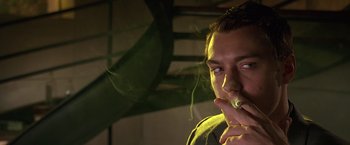 Movie still from “Gattaca” (1997), directed by Andrew Niccol – A man is smoking a cigarette in a dark room; Close Up shot, Low angle