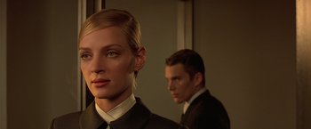 A man and a woman in suits in a room
