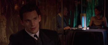 Movie still from “Gattaca” (1997), directed by Andrew Niccol – A man in a suit and tie sitting in front of a mirror; Close Up shot, Over the shoulder angle