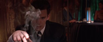 Movie still from “Gattaca” (1997), directed by Andrew Niccol – A man in a black suit and a white tie; Close Up shot, Over the shoulder angle