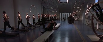 Movie still from “Gattaca” (1997), directed by Andrew Niccol – A group of people in a room doing various exercises; Wide shot, High angle