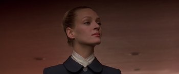 Movie still from “Gattaca” (1997), directed by Andrew Niccol – A woman in a suit looking to her left; Close Up shot, Low angle
