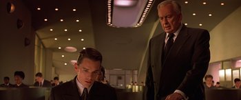 Movie still from “Gattaca” (1997), directed by Andrew Niccol – A man in a suit and tie standing next to another man in a suit and tie; Medium shot, Low angle