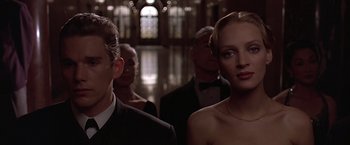 Movie still from “Gattaca” (1997), directed by Andrew Niccol – A man and a woman standing next to each other in front of other men; Close Up shot, Low angle