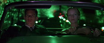 Movie still from “Gattaca” (1997), directed by Andrew Niccol – A man and a woman sitting in the back of a car; Medium shot, Low angle