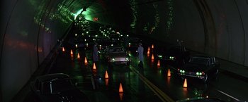 Movie still from “Gattaca” (1997), directed by Andrew Niccol – A couple of people standing next to some cars; Extreme Wide shot, High angle