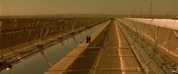 Movie still from “Gattaca” (1997), directed by Andrew Niccol – Two people are standing in front of a solar plant; Extreme Wide shot, High angle