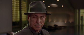 Movie still from “Gattaca” (1997), directed by Andrew Niccol – An older man wearing a suit and a hat; Close Up shot, Low angle