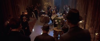 Movie still from “Gattaca” (1997), directed by Andrew Niccol – A group of people standing in a room with flowers; Wide shot, High angle