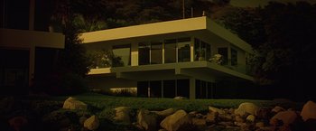 Movie still from “Gattaca” (1997), directed by Andrew Niccol – A large modern house sitting on top of a hill at night; Extreme Wide shot, Low angle