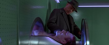 Movie still from “Gattaca” (1997), directed by Andrew Niccol – A man standing next to a man laying on the ground; Medium shot, Low angle