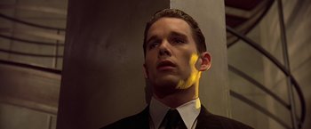 Movie still from “Gattaca” (1997), directed by Andrew Niccol – A man wearing a suit and tie looking up; Close Up shot, Low angle