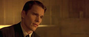 Movie still from “Gattaca” (1997), directed by Andrew Niccol – A man in a suit and tie looking to his left; Close Up shot, Over the shoulder angle