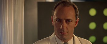 Movie still from “Gattaca” (1997), directed by Andrew Niccol – A person wearing a suit and tie; Close Up shot, Low angle