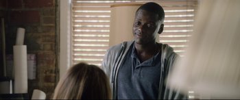 Movie still from “Get Out” (2017), directed by Jordan Peele – A man standing next to a woman in front of a window; Close Up shot, Over the shoulder angle