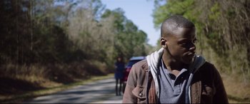 Movie still from “Get Out” (2017), directed by Jordan Peele – A young man standing next to a woman on the side of a road; Close Up shot, Over the shoulder angle