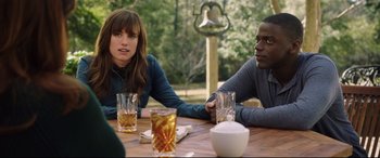 Movie still from “Get Out” (2017), directed by Jordan Peele – A man and a woman sitting at a table with drinks; Medium shot, Over the shoulder angle