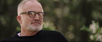 Movie still from “Get Out” (2017), directed by Jordan Peele – An older man wearing glasses and a black sweater; Close Up shot, Over the shoulder angle