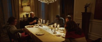 Movie still from “Get Out” (2017), directed by Jordan Peele – A group of people sitting around a dinner table; Medium shot, High angle